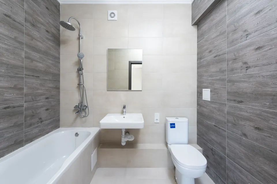 A contemporary bathroom with a tub, a sink and a toilet