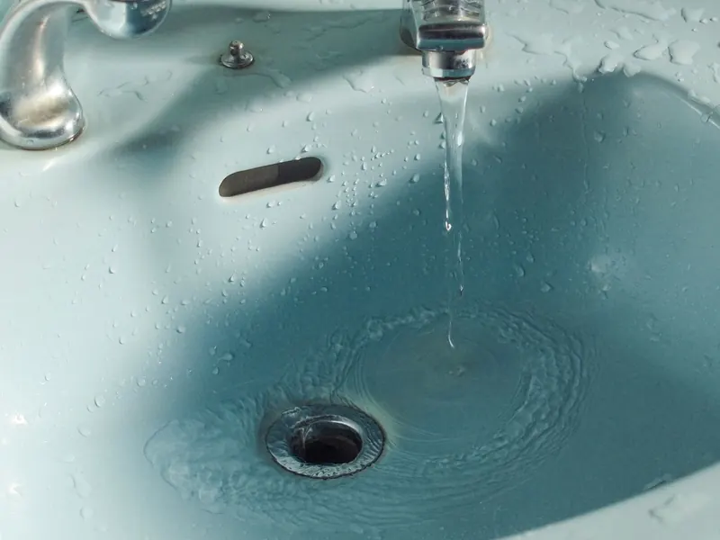 Water running from a faucet into a sink basin