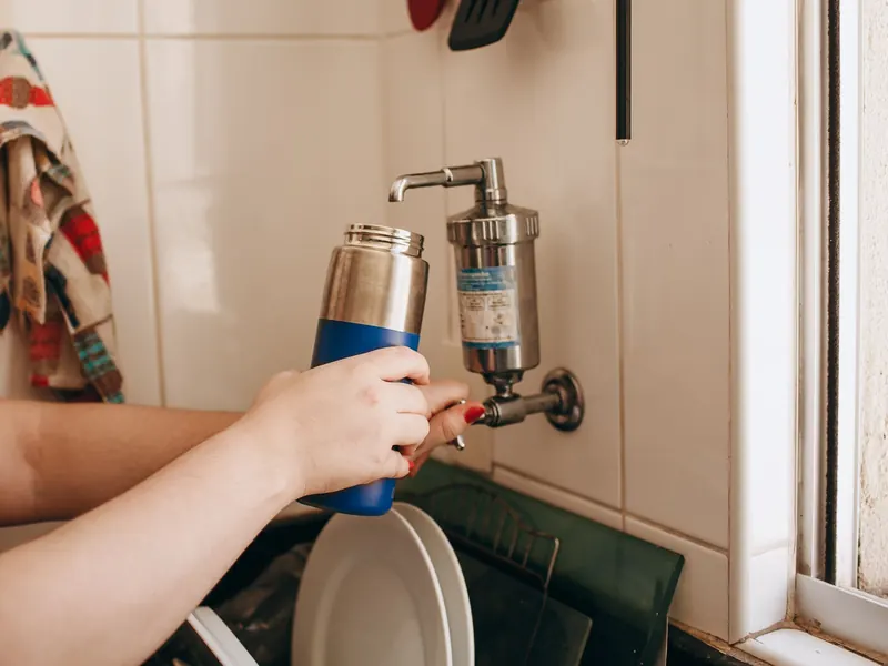 Filling a bottle at a kitchen tap fitted with a filter